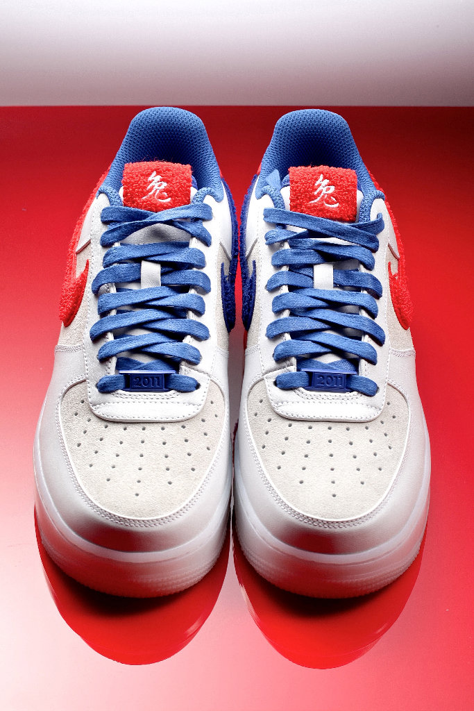 Пара белых кроссовок Nike AF1 с синими шнурками
