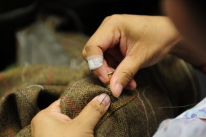 Обработка вручную отверстия под пуговицу на твидовом пиджаке